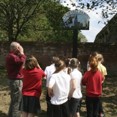 Gordon and the children examine the Tilney All Saints village sign